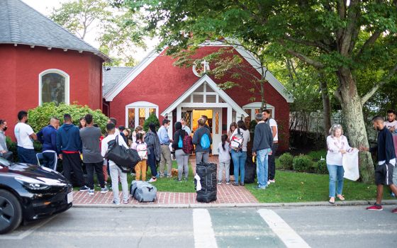 Venezuelan migrants stand outside St. Andrew's Episcopal Church Sept 14 in Edgartown, Massachusetts, on Martha's Vineyard. (CNS/Vineyard Gazette via Reuters/Ray Ewing)