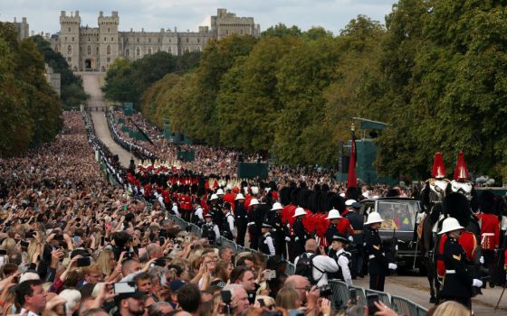 The hearse carrying the casket of Britain's Queen Elizabeth II is escorted along the Long Walk toward Windsor Castle toward her burial Sept. 19, 2022. (CNS photo/Paul Childs, Reuters)