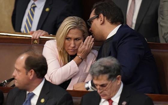 Rep.-elect George Santos, R-N.Y., right, talks with Rep. Marjorie Taylor Greene, R-Ga., during the ninth vote in the House chamber as the House meets for the third day to elect a speaker and convene the 118th Congress Jan. 5 in Washington. (AP photo/Alex Brandon)