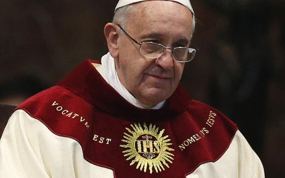 With the seal of the Society of Jesus on his vestments, Pope Francis celebrates Mass at the Jesuit Church of the Gesù in Rome Jan. 3, 2014. The Mass was celebrated on the feast of the Most Holy Name of Jesus in thanksgiving for the canonization of St. Peter Faber. (CNS/Paul Haring)