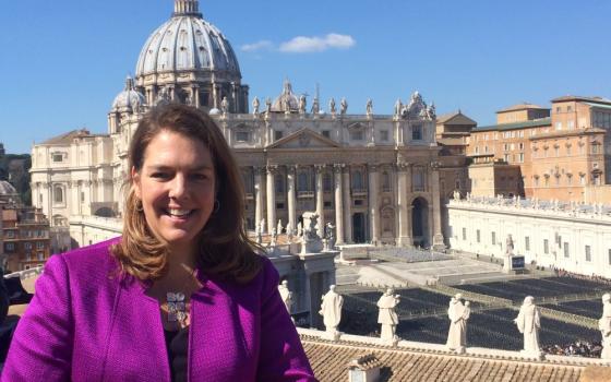 Kerry Alys Robinson stands outside on a roof that overlooks St. Peter's Square. 