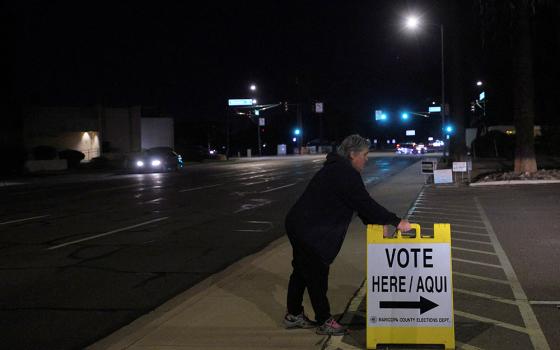 A poll worker puts out a "Vote Here" sign at a Phoenix polling location for the midterm elections Nov. 8, 2022. (CNS/Reuters/Brian Snyder)