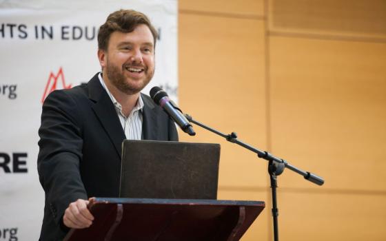 Greg Lukianoff stands at a lectern and speaks into a microphone.