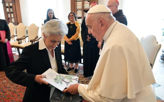 Pope Francis accepts gift from Ilva M. Hoyos Castañeda, a lawyer from Colombia, during a meeting with CEPROME.