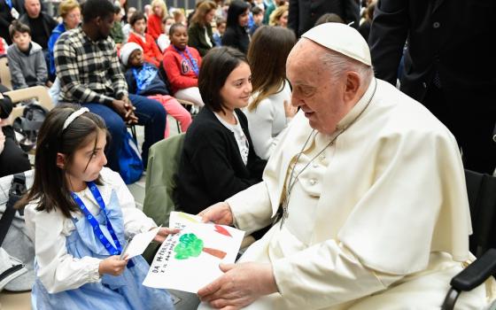 Pope Francis receives a drawing from a child