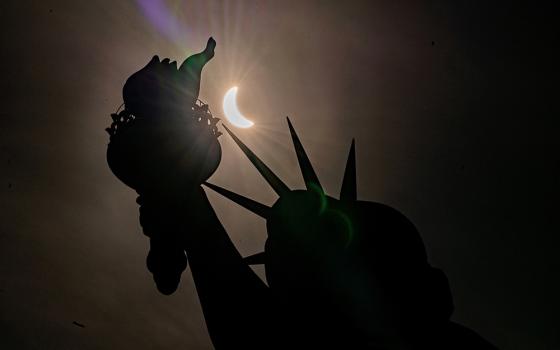 The Statue of Liberty is seen during a partial solar eclipse at Liberty Island April 8 in New York City. A partial eclipse was visible throughout all 48 contiguous U.S. states, while a total solar eclipse was visible along a narrow track stretching from Texas to Maine. (OSV News photo/Reuters/David Dee Delgado)