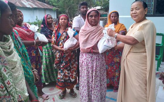 Sr. Minita Chisim hands out food to residents of the Bangladeshi village of Mariapolli, who lost their house, foods, and clothes in a storm April 9. Amid a cyclone May 26-27, the Congregation of Our Lady of the Missions Sisters also arranged shelter and provided food in their school for people in the southern village of Bagerhat. (Courtesy of Sr. Sukriti B. Gregory)