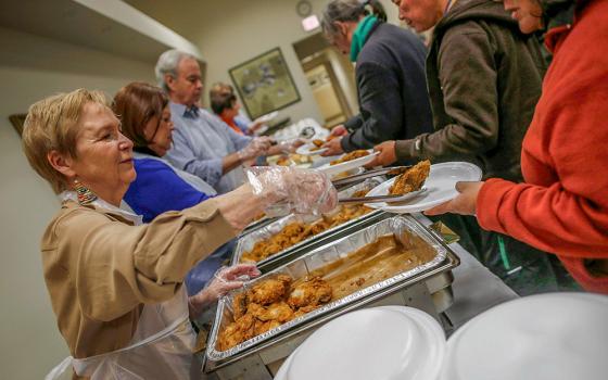 In a 2013 file photo, volunteers serve people during a free dinner provided by the Emergency Assistance Department of Chicago Catholic Charities. (CNS/Reuters/Jim Young)