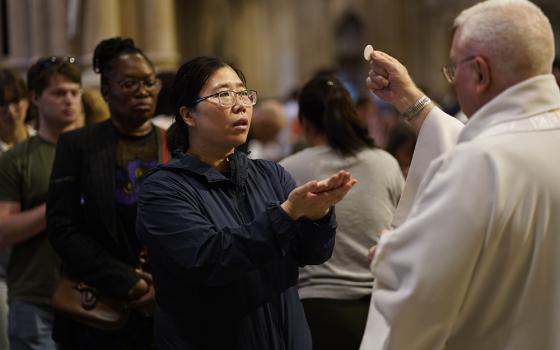 A woman receives Communion during Mass at St. Patrick's Cathedral in New York City May 26, 2024, the solemnity of the Most Holy Trinity. (OSV News/Gregory A. Shemitz)
