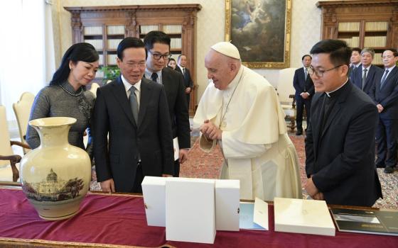 Francis, center, presents items to President and First Lady. 