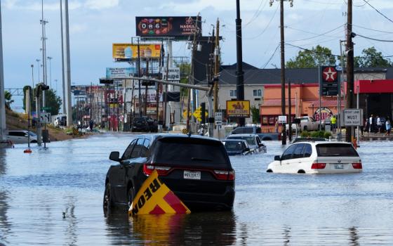 Major road flooded, floating cars. 