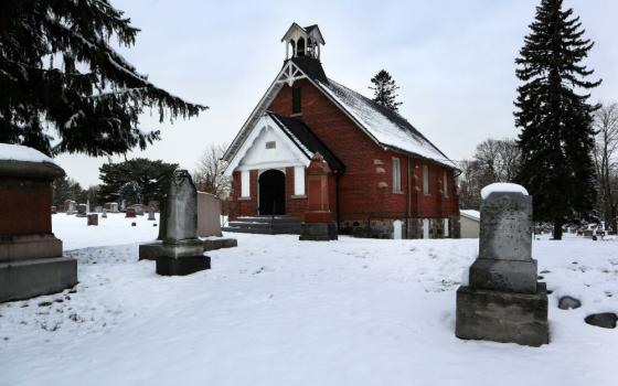 Gravestones stand near church.