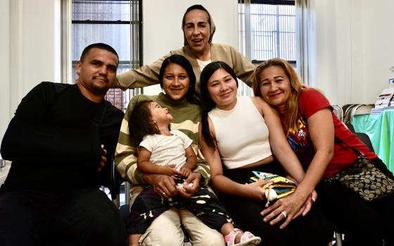 Venezuelan immigrants Carlos and Lisbeth Villamizar (far right), are pictured with their daughters Isis and Wuilmari, granddaughter Luciana, and Sr. Martha Lopez (top) at the resource fair sponsored by Catholic Charities of the Archdiocese of New York, at St. Teresa's Church in Manhattan's Lower East Side, in July 2024. (NCR photo/Camillo Barone)