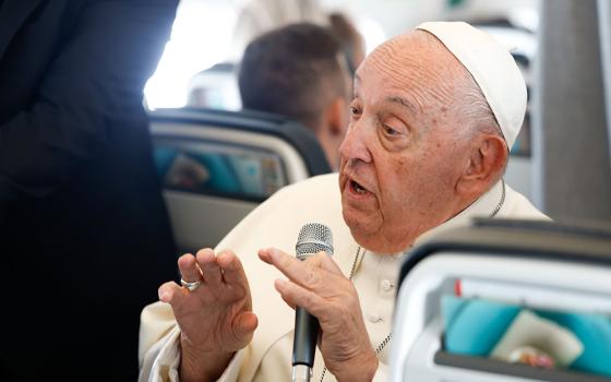 Pope Francis answers a question from a journalist aboard his flight back to Rome Sept. 29, after visiting Luxembourg and Belgium during his 46th international trip. (CNS/Lola Gomez)