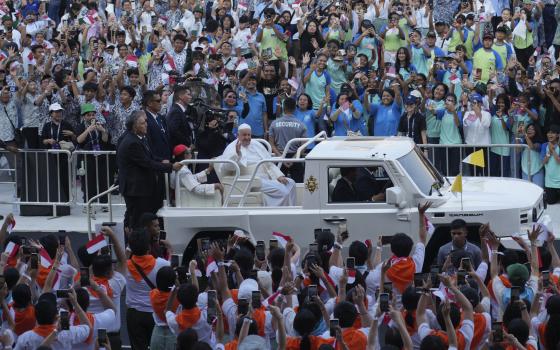 People react as Pope Francis arrives at Madya Stadium in Jakarta, Indonesia, Thursday, Sept. 5, 2024. (AP Photo/Tatan Syuflana)