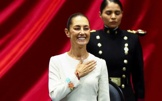 Sheinbaum holds her hand over her heart, in the background is a female soldier.