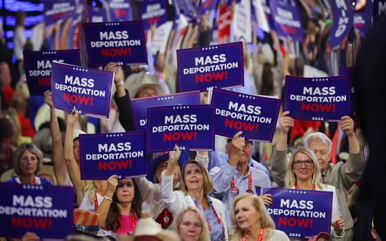 Delegates holds "Mass deportation now!" signs on Day 3 of the Republican National Convention at the Fiserv Forum in Milwaukee on July 17. (OSV News/Reuters/Brian Snyder)