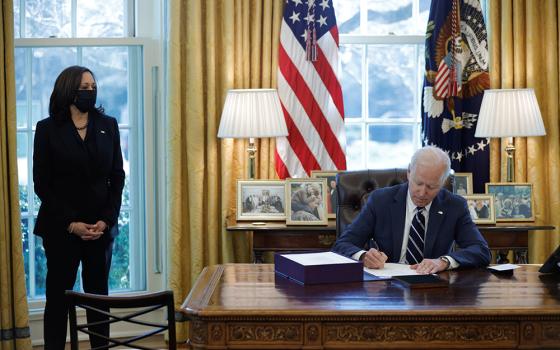 President Joe Biden signs the American Rescue Plan into law at the White House in Washington March 11, 2021. Also pictured is Vice President Kamala Harris. (CNS/Reuters/Tom Brenner)