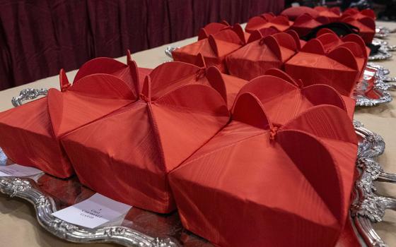 Red birettas, a three-pointed hat, sit on a table in St. Peter's Basilica at the Vatican Dec. 7 before Pope Francis' consistory to create new cardinals. (CNS/Vatican Media)