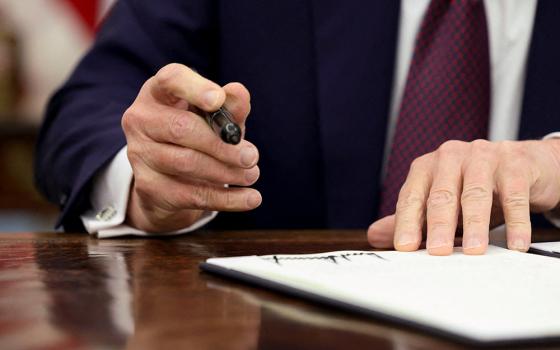 U.S. President Donald Trump signs an executive order in the Oval Office of the White House, Jan. 23 in Washington. (OSV News/Reuters/Kevin Lamarque)