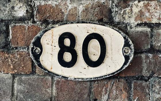 Number 80 on a brick wall (Unsplash/Jonny Gios)