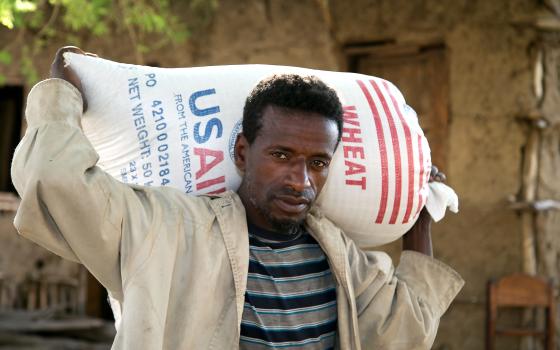 A man carries a bag of wheat supplied by Catholic Relief Services and USAID for emergency food assistance in a village near Shashemane, Ethiopia, in this 2016 photo. As acute hunger is expected to double in vulnerable populations because of the coronavirus pandemic, CRS launched an advocacy campaign May 14, 2020, to raise awareness about the world's hungriest people. (CNS Photo/Nancy McNally, Catholic Relief Services) 