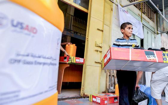 A boy is seen with relief goods at a U.S. Agency for International Development (USAID) distribution center in Gaza City. (OSV News/Shareef Sarhan, for Catholic Relief Services)