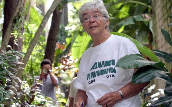 Stang wearing t-shirt and standing in forested area.