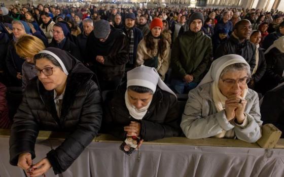 3 nuns pray with large crowd 