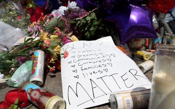 A memorial in Buffalo, New York, is seen May 17 in the wake of a weekend shooting at a Tops supermarket. A white man is accused of killing 10 people and injuring 3. Eleven of the victims were Black. (CNS/Reuters/Brendan McDermid)