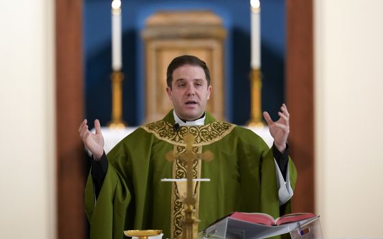 Father Matthew Hood celebrates mass at Our Lady of the Rosary church Friday, Feb. 18, 2022, in Detroit. (AP Photo/Paul Sancya)