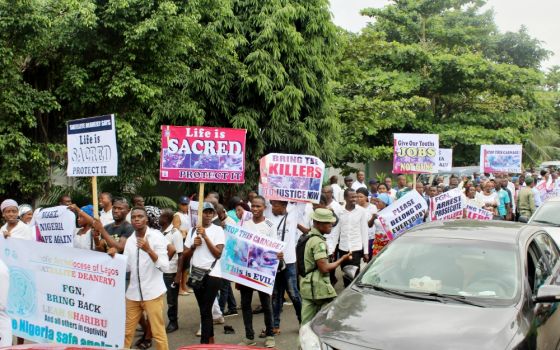 Crowds of people hoist placards, sing hymns and pray the rosary in Lagos May 22 during a peaceful and prayerful protest against recent killings in Nigeria. (Festus Iyorah)