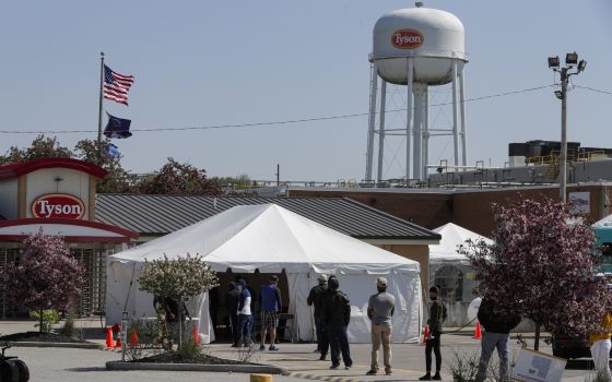 Workers wait in line to enter the Tyson Foods pork processing plant in Logansport, Ind., in this May 7, 2020 file photo. (AP/Michael Conroy)