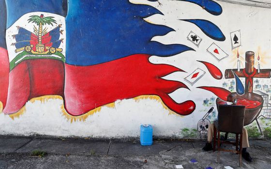 A man speaks on a phone next to a mural in the Little Haiti neighborhood of Miami July 8. (Newscom/Reuters/Shannon Stapleton)