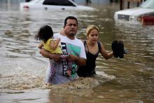 People wade through floodwaters in La Lima, Honduras, in November 2020, in the wake of Hurricane Eta. (CNS photo/Jorge Cabrera, Reuters)