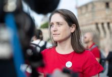 Kate McElwee, executive director of the Women’s Ordination Conference, speaks to a reporter during a "Don't Kick the Can, Women Can Be Priests” action in Rome during the Synod on Synodality meeting in October. The group is now planning a women’s strike during Lent of 2025. (Courtesy of Women's Ordination Conference)