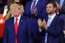 Trump and Vance stand looking up and smiling.