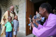 Archbishop Wilton Gregory poses with two boys after celebrating Mass at St. Augustine Church in Washington, D.C., June 2. (CNS/Catholic Standard/Andrew Biraj)